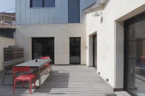 a patio with a table and chairs and a building at L'Echoppe - Maison 3 chambres avec 2 salles de bain et grande Terrasse in Talence