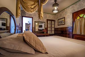 a bedroom with a large bed and a chandelier at Pousada Estalagem de Brotas in Brotas