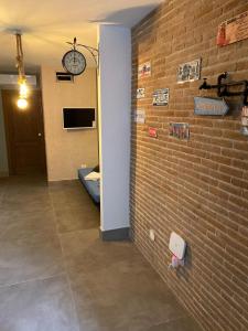 une chambre avec un mur en briques et une horloge sur un mur dans l'établissement MIKASA, à Naples