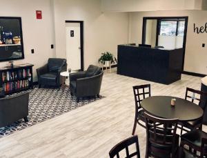 a waiting area with chairs and tables in a waiting room at University Inn Duke in Durham