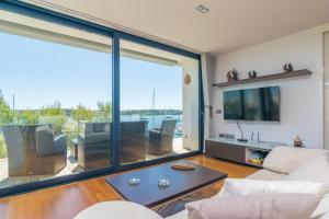 a living room with a large window with a view of the water at Llevant in Portocolom