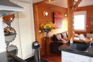 cocina con paredes de madera y sala de estar. en Au chalet d'Yport, en Yport
