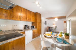 a kitchen with a table with a bowl of fruit on it at FLH Bairro Alto Charming Apartment in Lisbon