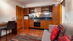 a living room with a couch and a kitchen at Stay Essential Apartments by Time Hotel & Apartments in Santiago