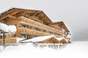 a building covered in snow in front at Hotel Brugger in Fulpmes