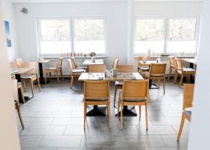 a dining room with tables and chairs and windows at Hanse Hotel Buxtehude in Buxtehude