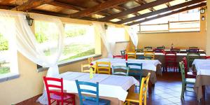 a restaurant with tables and colorful chairs in a room at Antica Melegnano in Atri