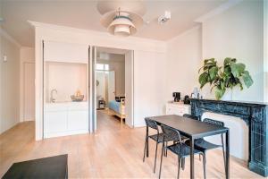a dining room with a table and a fireplace at The Greenplace Lodge. Apartment in Heart of Antwerp. in Antwerp