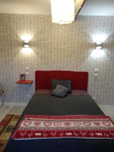 Un dormitorio con una cama roja con dos luces. en CHAMBRES D'HOTES, en Loudéac