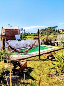 a playground with a hammock and a swimming pool at El Diablo en Paz in Punta Del Diablo
