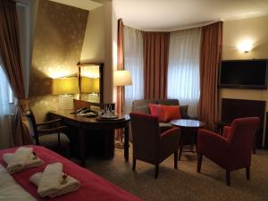 a hotel room with a desk and a bed and a table at Hotel Stare Miasto Old Town in Poznań