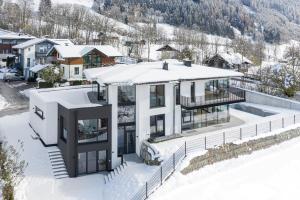 widok z powietrza na dom w śniegu w obiekcie lake and mountains appartements w mieście Maishofen