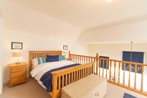 a bedroom with a bed and a wooden railing at Ardnave in Port Charlotte