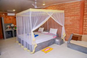 a bedroom with a canopy bed and a couch at Greenery Lanka Villa in Unawatuna