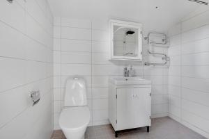 a white bathroom with a toilet and a sink at Fide Äventyrsby & Camping in Fidenäs +29 photos