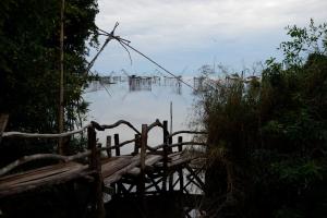 a view of a body of water with a wooden bridge at Baan​ Tonlamphu​ Pakpra in Phatthalung