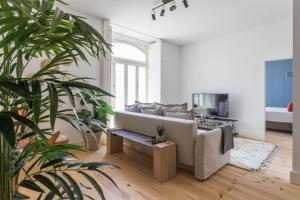 ein Wohnzimmer mit Sofa und einigen Pflanzen in der Unterkunft FLH Cais Sodré Charming Flat in Lissabon