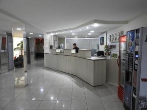a man sitting at a counter in a store at Hotel Binder Quality Inn in Mogi das Cruzes