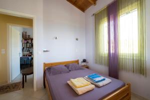 sypialnia z łóżkiem z dwoma ręcznikami w obiekcie Balcony of Argolis gulf w mieście Tolo