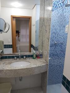 y baño con lavabo, espejo y ducha. en Flat Parque Ibirapuera, en São Paulo