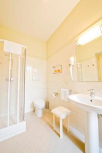 a white bathroom with a sink and a toilet at Gästehaus Deutscher Orden in Rome