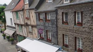 einen Blick über ein Gebäude mit Blumen an den Fenstern in der Unterkunft Carpe diem in Honfleur
