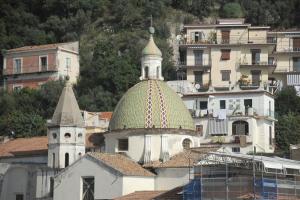 un edificio con una cupola verde sopra di esso di Apartments Cetara a Cetara