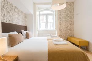 um quarto com uma cama grande e uma cadeira amarela em FLH Downtown Fantastic Flat em Lisboa
