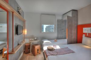 a small bedroom with two beds and a tv at ibis budget Nice Californie Lenval in Nice