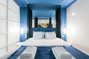 リスボンにあるFLH Chiado Modern Placeの青いベッドルーム(白いベッド、青いヘッドボード付)