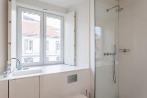a bathroom with a sink and a window and a shower at FLH Downtown Amazing Flat in Lisbon