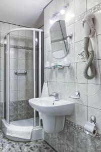 biała łazienka z umywalką i prysznicem w obiekcie Hotel Konin w Koninie