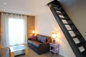 a living room with a couch and a staircase at Appartement du Tourisme in Zonza