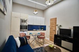 een woonkamer met een blauwe bank en een tafel bij W18 Design Apartments - Budapest Downtown in Boedapest