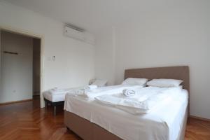 a bedroom with two beds with white sheets at Old Town Premium Apartment in Sarajevo