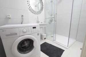 a white bathroom with a washing machine and a shower at Old Town Premium Apartment in Sarajevo +13 photos