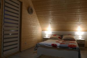 a bedroom with a bed with two lamps on two tables at Domki pod Polaną in Lesko +20 photos