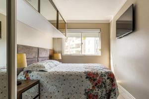 1 dormitorio con 1 cama con colcha de flores en Excelente apt para veraneio em Floripa!, en Florianópolis