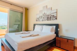 een slaapkamer met een bed met twee handdoeken erop bij FLH Funchal Green Park Apartment with Pool in Funchal