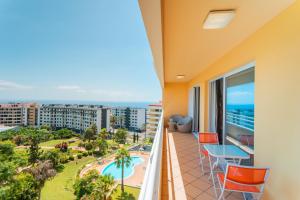 een balkon met uitzicht op het zwembad en de oceaan bij FLH Funchal Green Park Apartment with Pool in Funchal