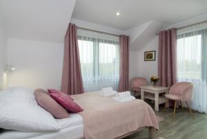 sypialnia z łóżkiem z różowymi poduszkami w obiekcie Za Gościńcem w Kazimierzu Dolnym