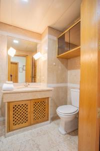 ein Badezimmer mit einem WC, einem Waschbecken und einem Spiegel in der Unterkunft FLH Funchal Amazing Sea View Apartment with Pool in Funchal