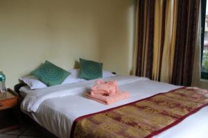 Llit o llits en una habitació de Hotel Noble Inn花椒客栈