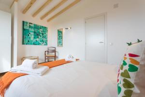 une chambre blanche avec un lit avec des serviettes dessus dans l'établissement FLH Garden Houses near Ericeira, à Sintra