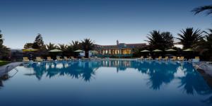 a large swimming pool with chairs and umbrellas at Forte de São Francisco Hotel Chaves in Chaves