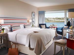 a bedroom with a large bed and a large window at Trident Hotel Kinsale in Kinsale