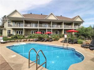 hotel z basenem przed budynkiem w obiekcie Spacious Condo - Pool & BBQ - Ski, MTB, Golf, Telework - Le Champlain w mieście Bromont