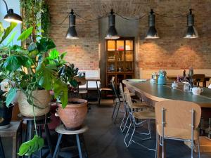 a restaurant with a large table and some plants at Linnen in Berlin