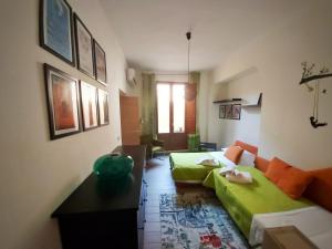 シラクーサにあるA Casa di Valeのベッド2台と緑のソファが備わる客室です。