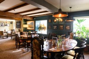 a dining room with wooden tables and chairs at The St George and Dragon by Innkeeper's Collection in Topsham
